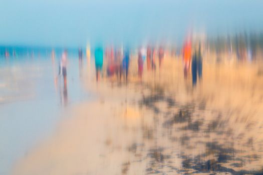 Abstract photo effect of people walking on the beach in the colorful impressionist style. Soft focus. A blurring technique creates a unique impressionist style. Pastel colours.