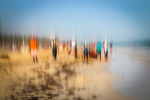 Abstract background image of people walking on the beach in the style of the Impressionists. Soft focus. A blurring technique creates a unique impressionist style. Pastel colours.