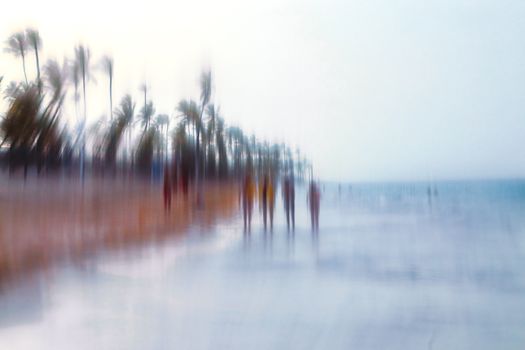 Abstract background image of people walking on the beach in the style of the Impressionists. Soft focus. A blurring technique creates a unique impressionist style. Pastel colours.