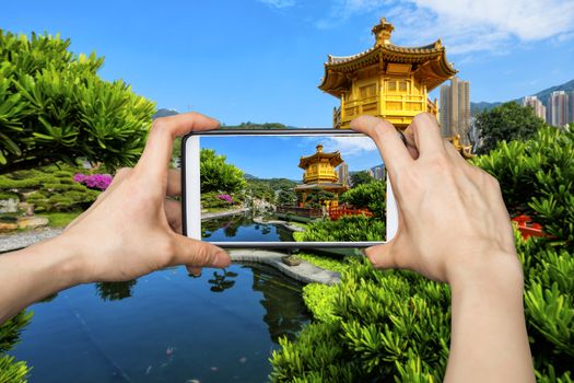 Girl taking pictures on mobile smart phone in Jiuzhaigou National Park,China