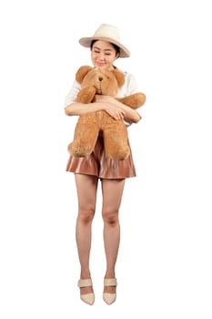 Lovely smiling young woman with hat holding big soft teddy bear on white background with clipping path 