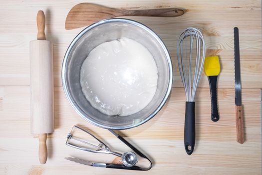 Food ingredients and kitchen utensils for cooking on wood background