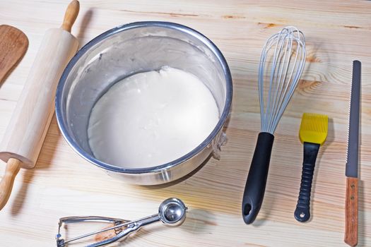 Food ingredients and kitchen utensils for cooking on wood background