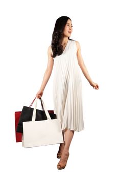 a happy women in white dress with a shopping bag on white background and clipping path 
