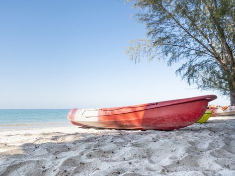 A red kayak on a beach.