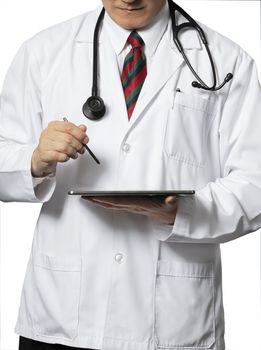 A standing doctor in long white hospital gown with a black stethoscope and a tablet. Isolated on white background.