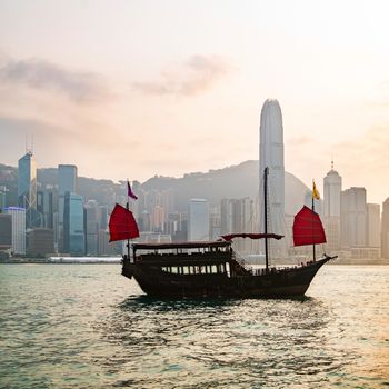 Hong Kong skyline with a traditional boat seen from Kowloon, Hong Kong, China.