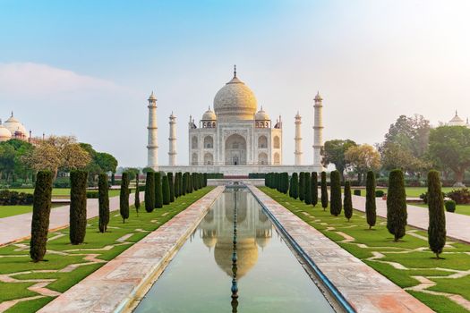 Taj Mahal front view reflected on the reflection pool, an ivory-white marble mausoleum on the south bank of the Yamuna river in Agra, Uttar Pradesh, India. One of the seven wonders of the world.