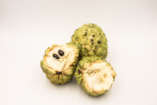 Three custard apples placed on a white ground.