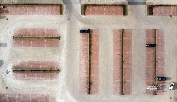 Vertical aerial photo taken from an empty parking lot of a consumer market, abstract aerial view, made with drone