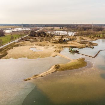 Obliquely photographed aerial photograph of a wet mining operation for sand and gravel, aerial photograph from the water side, drone shot