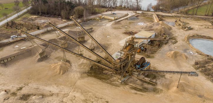 Oblique aerial photograph with the overall view of a large processing machine when used in a sand quarry, to divide the dredged material into different fractions, drone shot