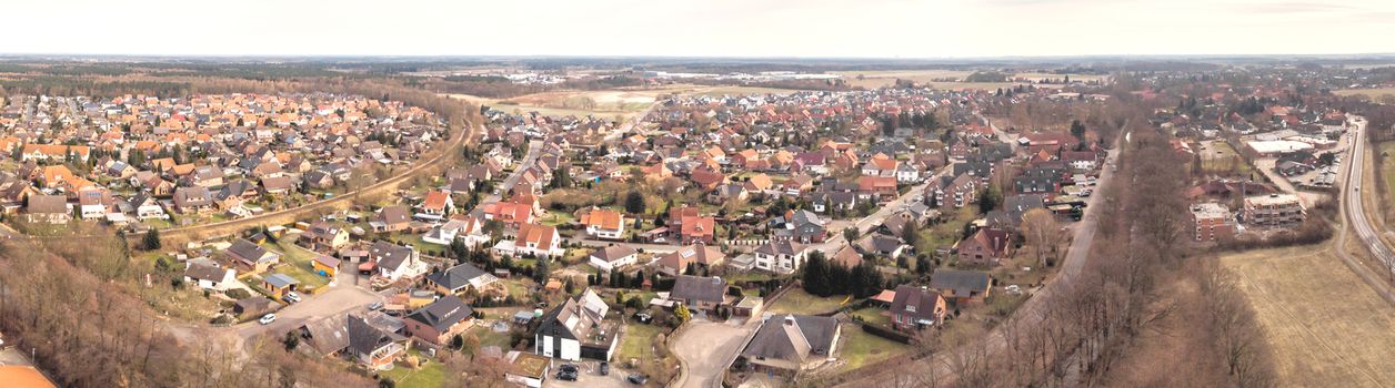 Composite panorama of aerial photographs and aerial photos of a small village in the heath in Northern Germany with meadows, fields and houses, above the roofs, made with drone