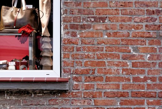 Old brickwork made of red weathered bricks next to a big window, abstract photo.