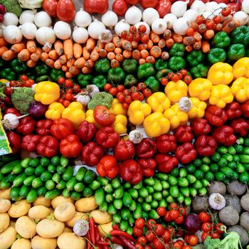 A stand with vegetables such as yellow pepper, beetroot, tomatoes, cucumber, pumpkin, carrots, radish, beetroot, garlic and more