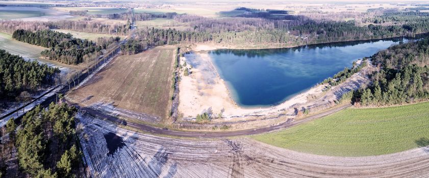 Aerial landscape photo, aerial photo with a lake, fields, meadows, forests and a road, panorama as a banner for a blog or a website, drone landscape photo.