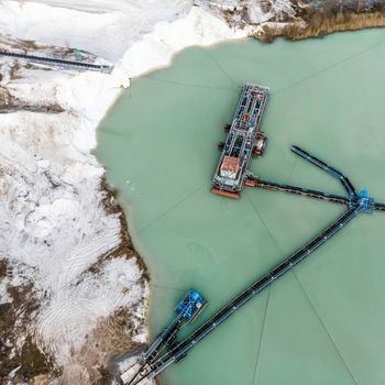 Aerial photograph of a large suction dredger in a wet mining process for quartzite snow-white sand, made with drone