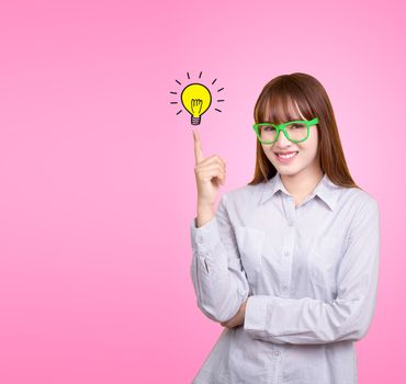 Business Asian woman with green glasses stand and have idea lamp bulb light on women fingertip pink background, for your design for poster and advertising text. Beautiful Asia female model in her 20s.