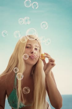 Blonde girl and soap bubbles in summertime, travel and beach lifestyle concept