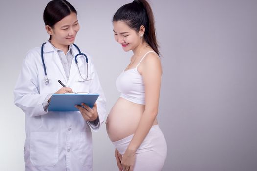 Pregnancy, motherhood, people, medicine and fertility concept - happy pregnant woman with doctor at maternity hospital.