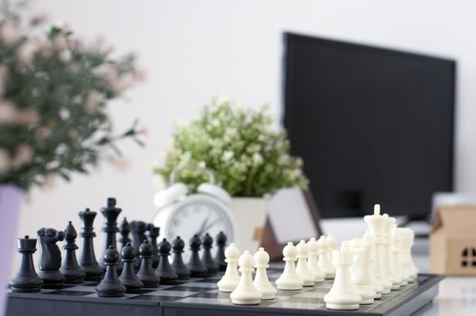 Chess board. Business concept. Business Strategy. Work table with chess board games. Win Competition with good strategy. White Alarm clock and computer on work desk. Data financial analysis.