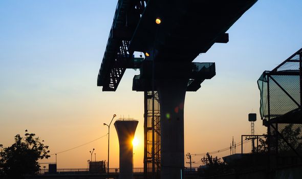 Sunset on the Poles and structures that are under construction. silhouette on building in the city.