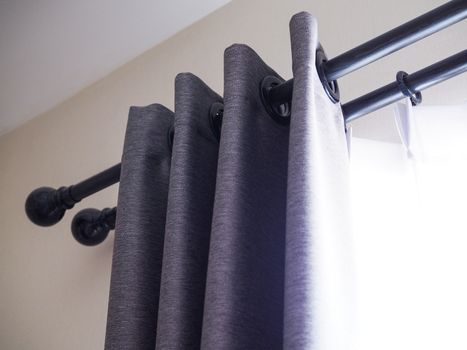 gray curtains and white sheer with ring-top rail. Decorate the window and interior design of the room in house.