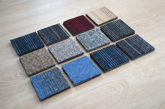 Sample of carpets on wood background. Carpet tiles materials use for Interio designer. Home construction decorate room with luxury Carpets set. Materials for renovate new room and Office.