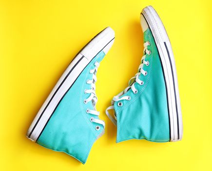 Blue sneakers Teen Fashion shoe isolated on yellow background.