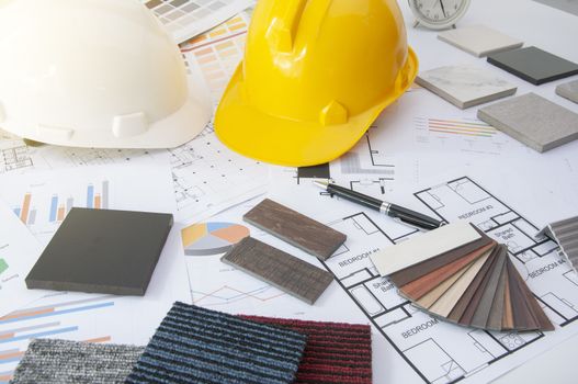 Materials construction. Home materials for Engineer and architec. Safety helmet on work table. Home budget and plan with materials design. Sample of wood laminate and carpet.