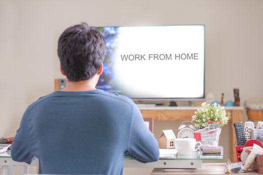 A man work from home.Work from home. Man wear blue shirt sitting in Living room for work at home.