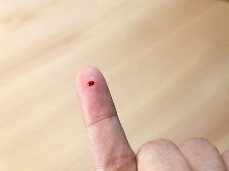 Close up of female finger with blood drop for blood testing