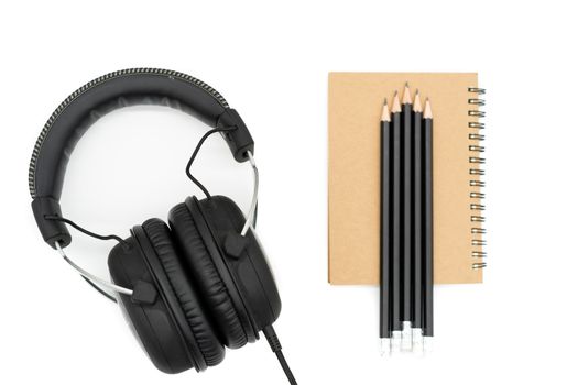 Headphones on the left side of the picture book, on the right side of the picture and there are 5 pencils on top of all brown books, placed on a white background.