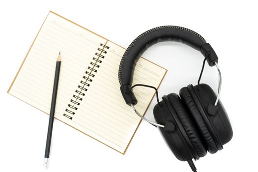 Books were placed under pencils and headphones, all on a white background.
