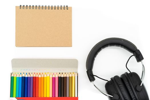 24 wooden colors are packed in a brown paper box placed at the bottom left of the picture and brown book is placed in the top left corner of the picture, the headphones are at the bottom All right angles are placed on a white background.