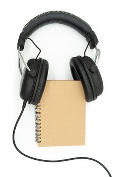 The book is between the headphones in the middle of the image on a white background