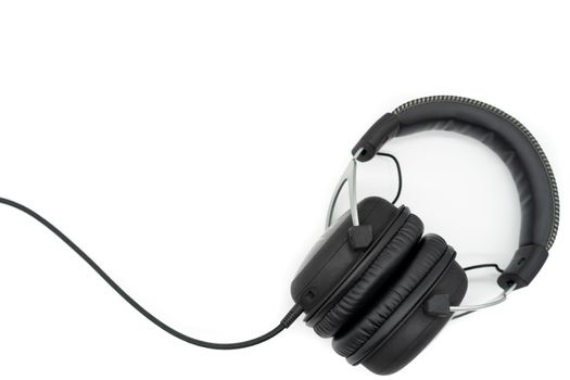 The black headphones place the bottom left hand corner of the image on a white background.