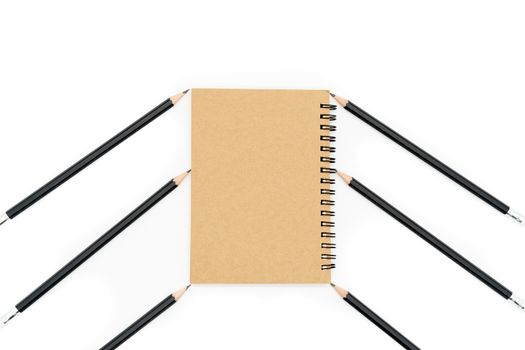 This brown book is placed between 6 black pencils and all on a white background.
