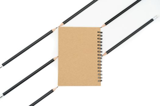 This brown book is placed between 6 black pencils in diagonal lines and all on a white background.