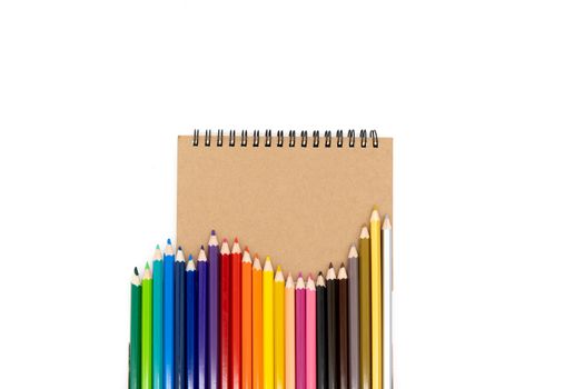 24 colored pencils set in a wave on books and on a white background