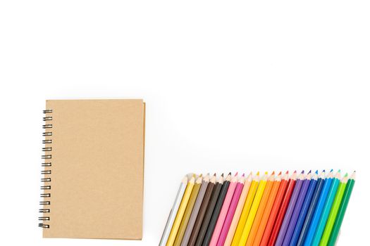 This brown book is placed on the left side of the picture and 24 colored pencils, arranged diagonally at the bottom right corner of the picture and on a white background.
