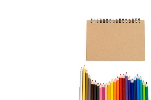 24 colored pencils arranged in a wave pattern are at the bottom right of the picture and the book is in the top corner to the right of the picture and all are on a white background.