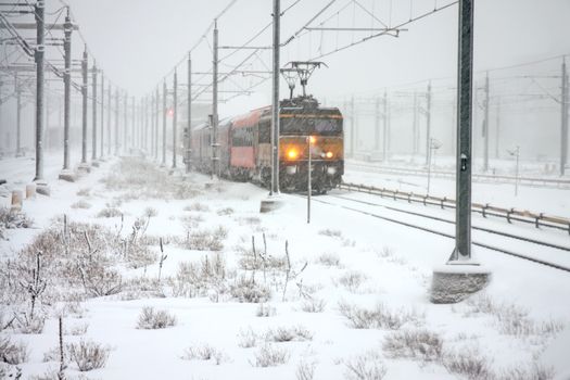 Train driving in snowstorm in winter in the Netherlands