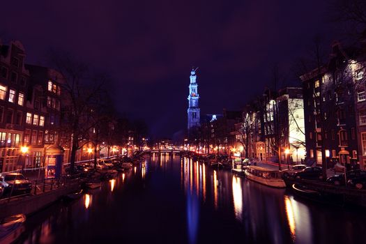 City scenic from Amsterdam with the Westerkerk in blue in the Netherlands at night