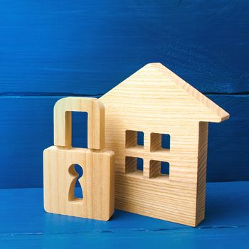 Wooden house with a padlock. Buying a home. House with a lock. Security and safety, collateral, loan for a mortgage. Confiscation of property for debts. Safety and alarm system.