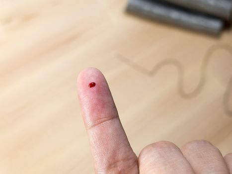 blood at finger accident by needle from sewing