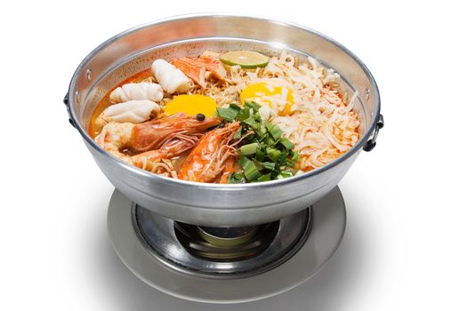 Pot of spicy instant noodles with Cheese isolated on white background. Topping with egg , seafood , shrimp, squid, crab ,lemon and coriander