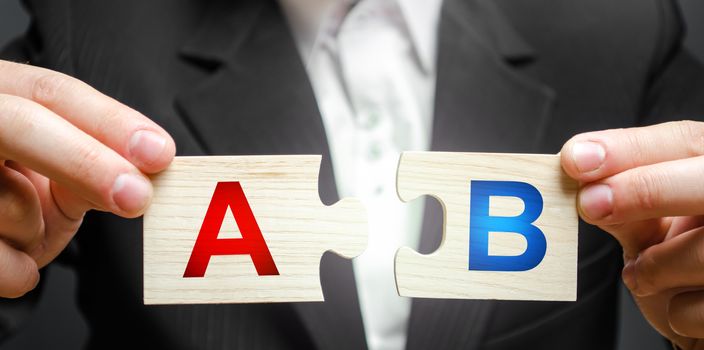 A man connects puzzles with the letters A and B. A/B test marketing research method. multivariate testing. Improving products and services based on statistics and observations. Marketer