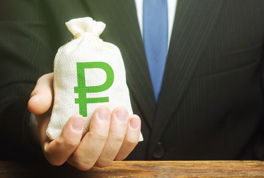 Man holds out a russian ruble money bag. Provision of money on credit, grant. Project financing. Donations. Financial social assistance. Payment purchases, profits dividends. Business investment