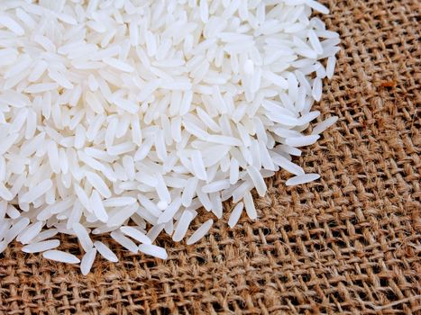 Thai jasmine rice in sack, white rice on burlap sack background with rice grain close up
